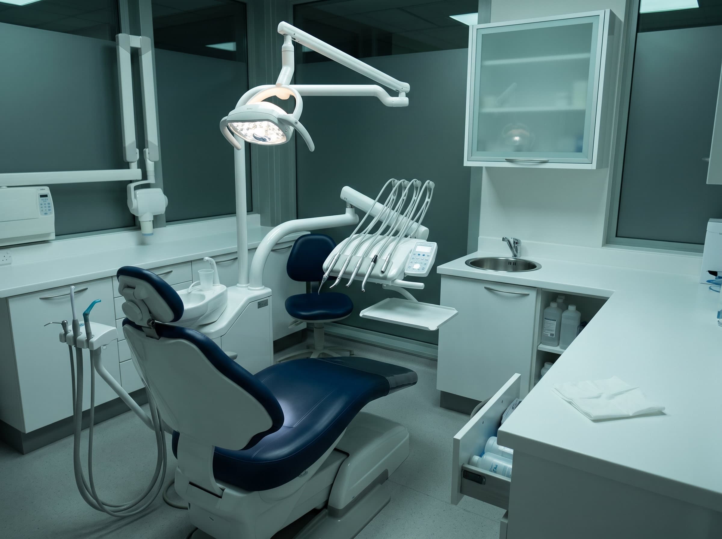 A dental operatory after cleaning, chair and counters gleaming under the exam light